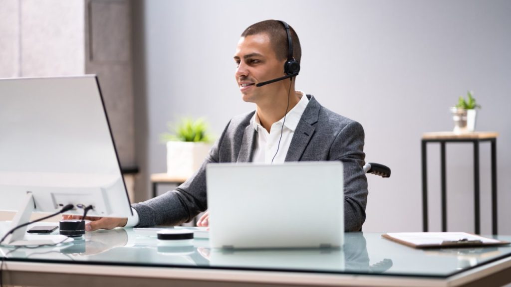 a-virtual-assistant-wearing-a-headset-working-diligently-on-their-computer-and-laptop-to-provide-remote-administrative-support-to-clients