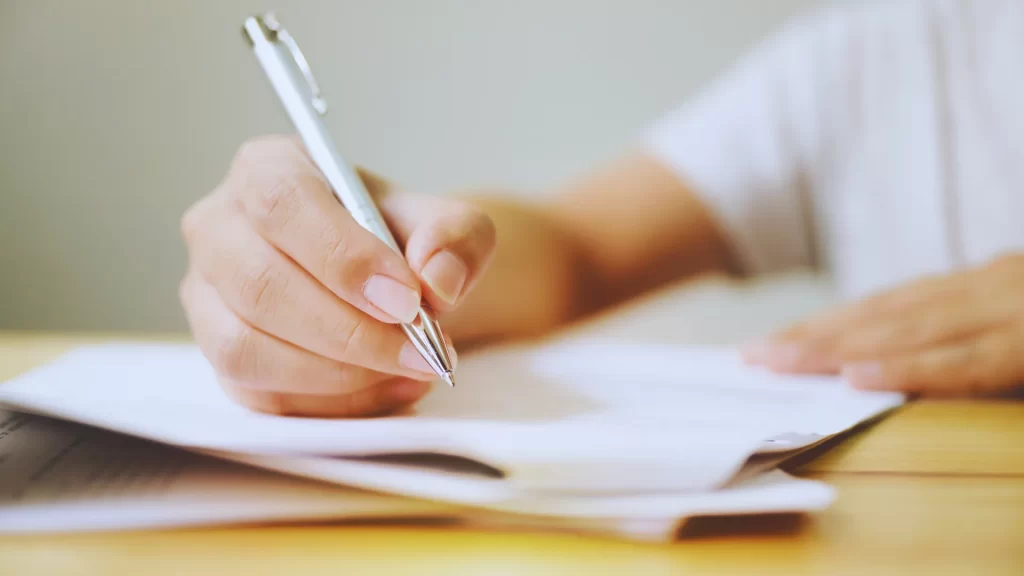 close-up-of-a-person-writing-on-paper-with-a-pen