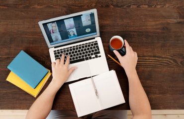 person-working-on-traffic-engineering-projects-taking-notes-with-a-pen-and-notebook-using-a-laptop-having-a-meeting-with-team-members-drinking-tea-and-having-a-pencil-nearby