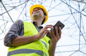 virtual-traffic-engineer-using-phone-while-wearing-yellow-helmet-with-a-smile-on-face-working-on-tasks-related-to-traffic-engineering-virtually